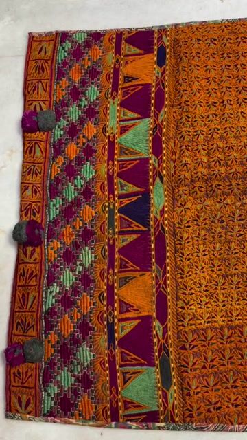 Pashtun Afghan embroidery is a vibrant, intricate needlework tradition, featuring rich silk, metallic thread, and mirror work (shisha) on clothing like dresses (kameez), vests, and veils. Characterized by colorful, geometric, or floral patterns, it is a crucial, time-intensive sk